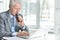 Portrait of senior man using laptop in office