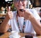 Portrait of senior smiling woman having break at coffee shop with chocolate cake and coffee cup. Carefree elderly woman with