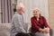 Portrait of senior spouses sitting on sofa