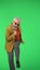 Portrait of senior stylish hipster on Chroma key green screen background, man dancing looking cool at the camera