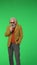 Portrait of senior stylish hipster on Chroma key green screen background, man in headphones sings in microphone