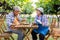 Portrait of senior winemaker holding in his hand a glass of new white wine. Smiling happy elderly couple enjoying a picnic