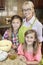 Portrait of a senior woman with granddaughters in kitchen