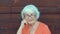 Portrait senior woman with gray hair looking in camera on wooden wall background