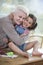 Portrait of senior woman hugging granddaughter sitting on table at home