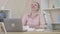 Portrait of senior woman laughing out loud as sitting at the table with pile of used tissues. Stressed Caucasian lady