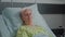 Portrait of senior woman laying in hospital ward bed