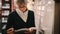 Portrait of a senior woman looking at a book in library