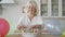 Portrait of a senior woman preparing cake for her child or grandchild. Birthday celebration concept. Caring granny