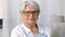 Portrait of senior woman reading newspaper at home