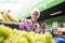 Portrait of senior woman sells raspberries on market
