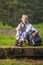 Portrait of Senior Woman With Tourist Backpack Dreaming in Forest Outdoors On Nature Background