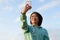 Portrait of sensual japanese woman with short hair taking selfie outdoor using her phone. Blue cloudy sky background