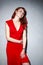 Portrait of Sensual Tranquil Female Girl Posing in Red Dress in Studio Against White Wall