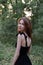 portrait of sensual young woman in a black dress in the forest. freedom, loneliness. nature loving