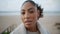 Portrait serene african american woman look camera at blurred ocean background.