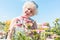 Portrait of a serene senior woman standing in the garden in a su