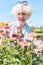 Portrait of a serene senior woman standing in the garden in a sunny day