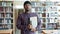 Portrait of serious African American student holding books in university library