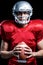 Portrait of serious American football player holding ball