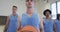 Portrait of serious caucasian male basketball player and diverse male team on court, slow motion