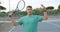 Portrait of serious caucasian male tennis player with racket and ball on outdoor court, slow motion