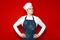 Portrait of a serious chef on red isolated background, kitchen worker in uniform