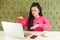 Portrait of serious concentration blind young woman with black dreadlocks hairstyle in pink blouse are sitting in cafe and