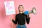 Portrait of serious and confident young feminist girl isolated over pink background