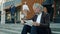 Portrait of serious entrepreneur reading business papers sitting on stairs of office center