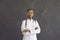 Portrait of serious ethnic woman doctor in white coat