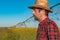 Portrait of serious farmer standing in front of center-pivot irrigation equipment in rapeseed field