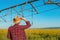 Portrait of serious farmer standing in front of center-pivot irrigation equipment in rapeseed field