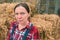 Portrait of serious female farmer in front of haystack