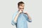 Portrait of serious handsome young man in light blue shirt standing in boxing fists, looking at camera and ready to attack or