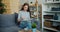 Portrait of serious lady reading book on sofa in apartment focused on activity