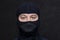 Portrait of a serious man in a balaclava. A black mask on his face, hides his appearance. Perhaps he is a criminal or a hacker, a