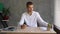 Portrait of a serious man drinking pure mineral water from a glass in the office. businessman drinks clean water