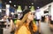 Portrait of a serious model in a cap and an orange hoodie poses on the camera in a fast food restaurant, looking away