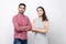 Portrait of serious proud handsome man in red checkered shirt and beautiful woman in white striped dress standing and looking at