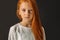 Portrait of serious redhaired girl isolated over black background