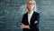 Portrait of serious smart lady professor in classroom with formulas on chalkboard