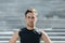 Portrait of serious sportsman. Young man on blurred city stairs background