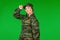 Portrait of a serious strong military woman on a green background with blank space. The concept of gender inclusivity in