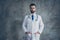 Portrait of serious talented doctor put his hands in pockets of white coat look ready to cure patients in clinic