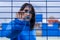 portrait of a serious woman dressed in blue behind a fence leaning her hand on it