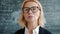 Portrait of serious woman scientist in glasses looking at camera in university class