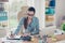 Portrait of serious young businesswoman accountant in formal wear and with pony tale, sitting at her work place and doing notes