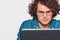 Portrait of serious young man sitting at his desk with laptop. Closeup image of Caucasian businessman working in office