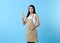 Portrait of service minded asian woman employee showing an Okay sign gesture studio shot on blue background